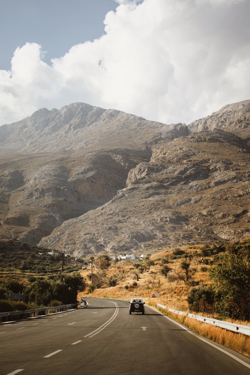 a car driving down a road in the mountains